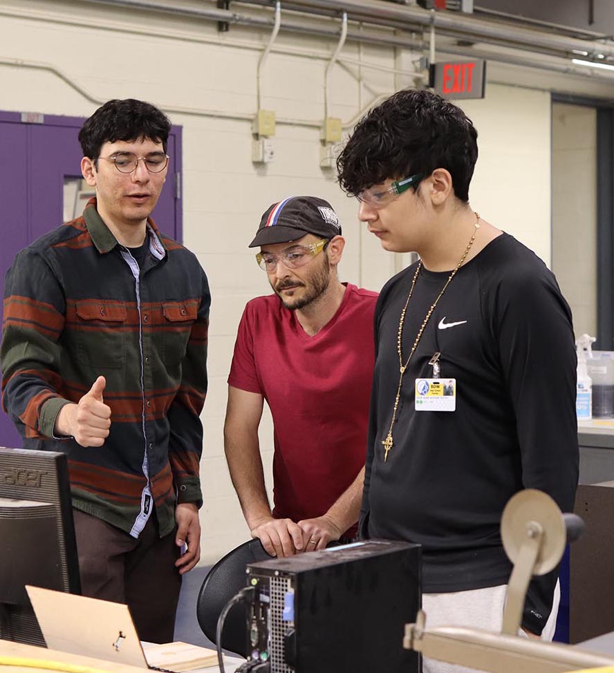 Blackstone Academy teachers looks on as Brown student showcases design software on a computer