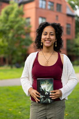 Selam Demeke holds up a book 