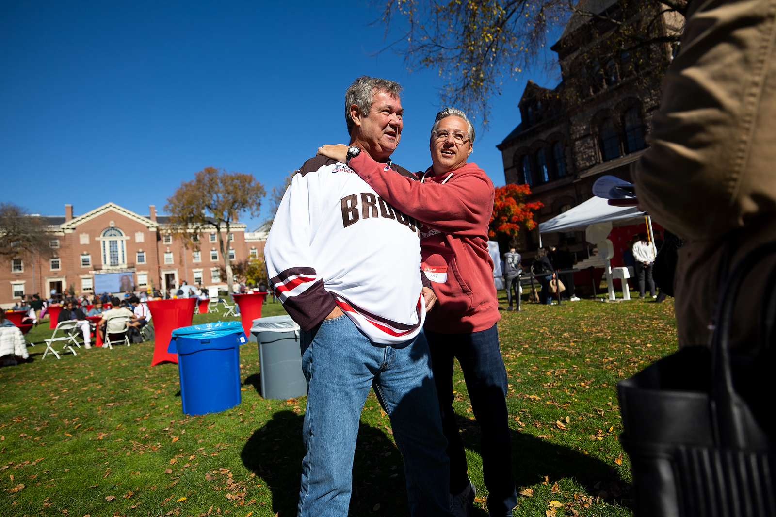 Family visitors hug while chatting on the college green