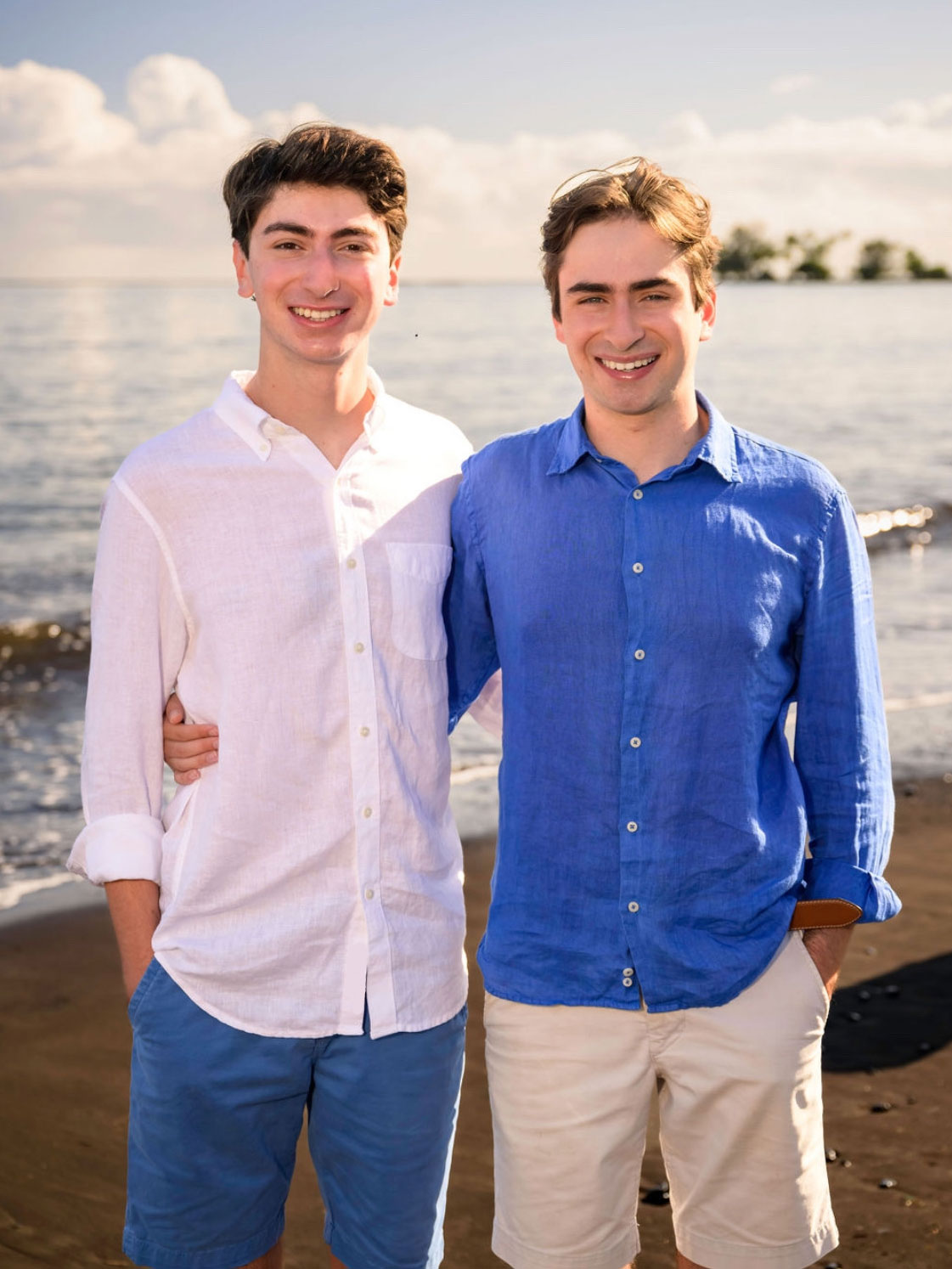 Joshua and Benjamin Moshes stand on the beach for a portrait