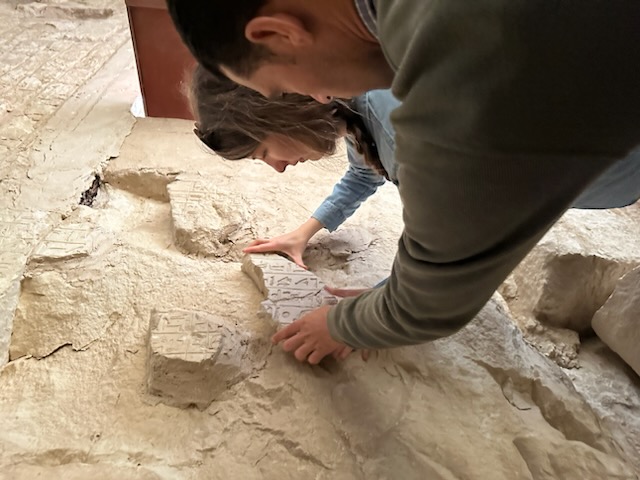 two people examine a pyramid wall