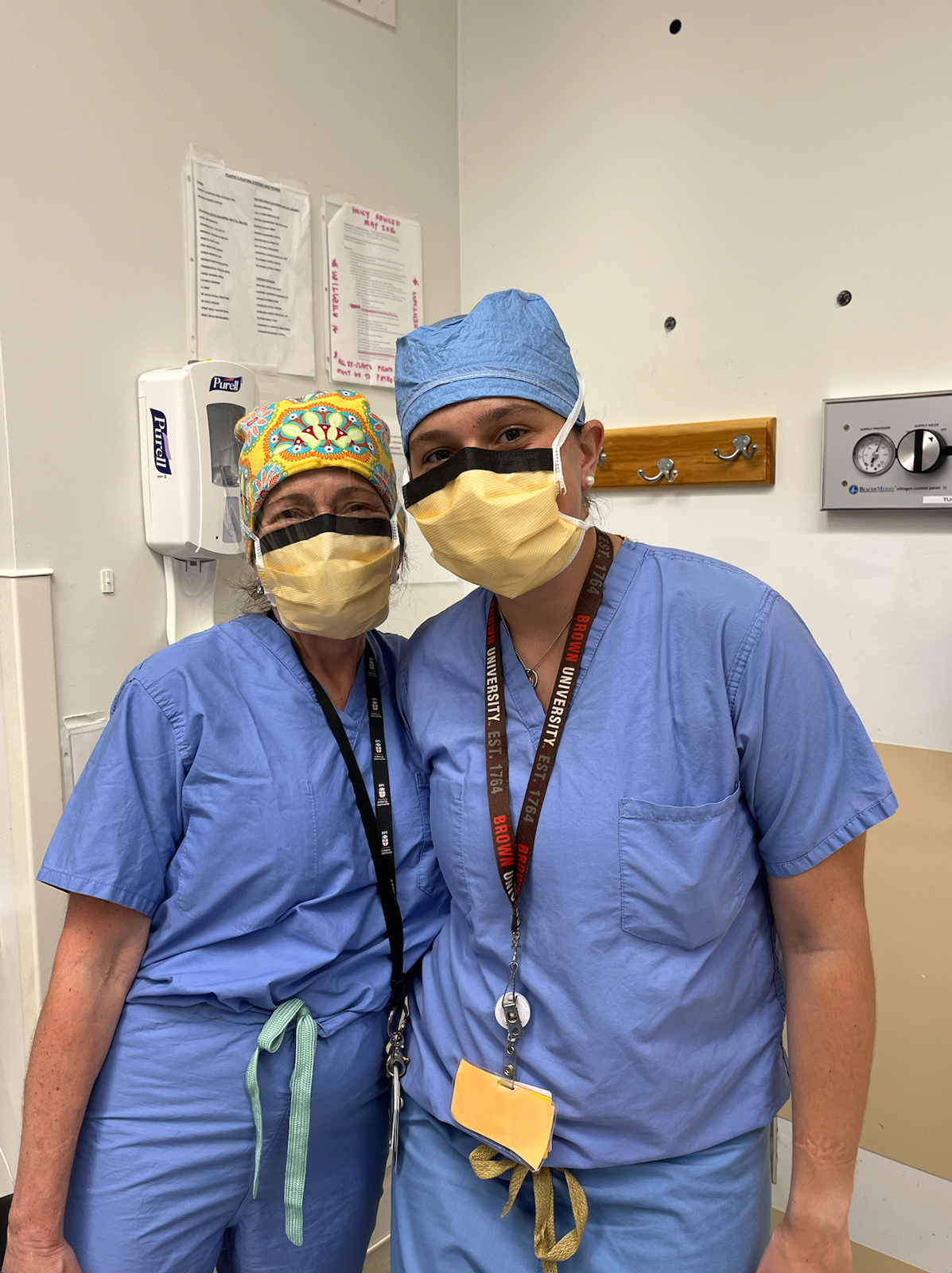 student stands with doctor in full scrubs