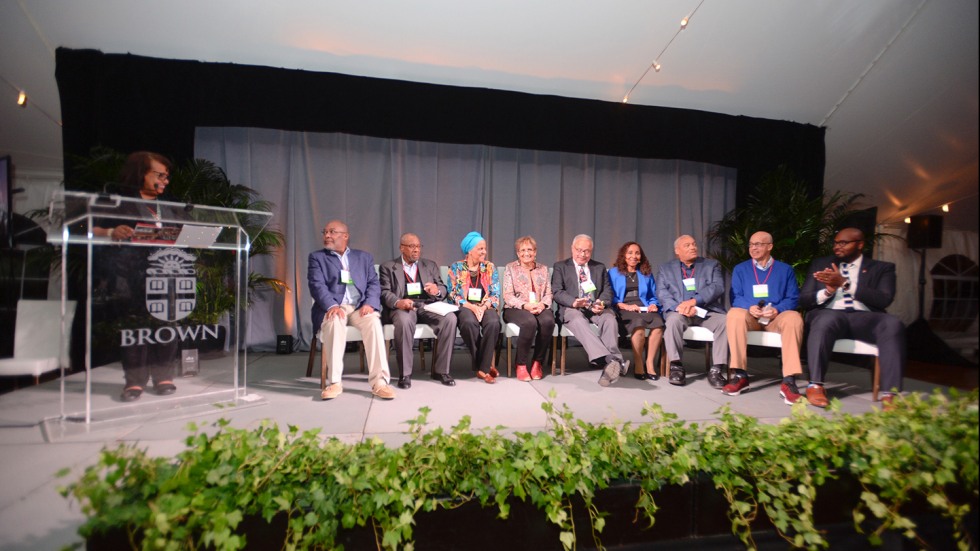 Panel of nine people on stage