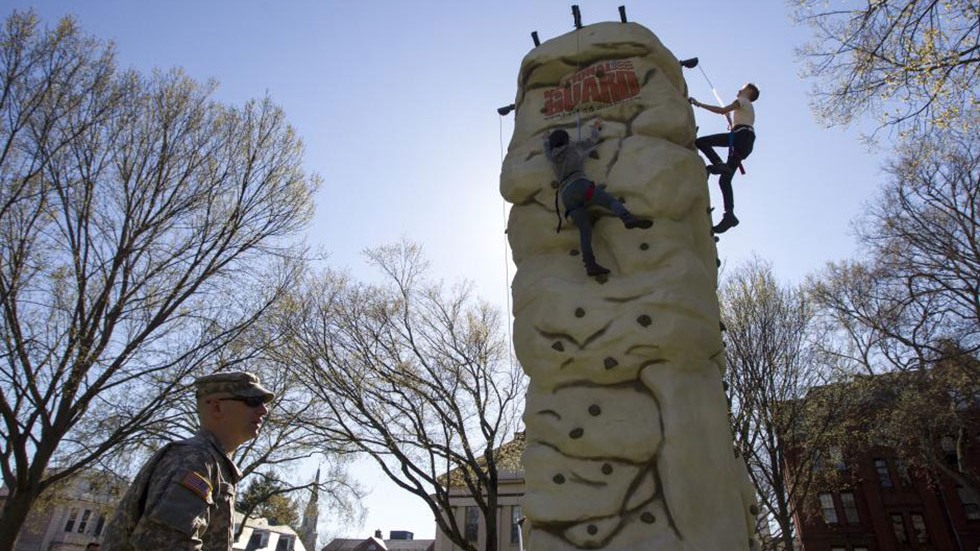 attendees climb a rock wall