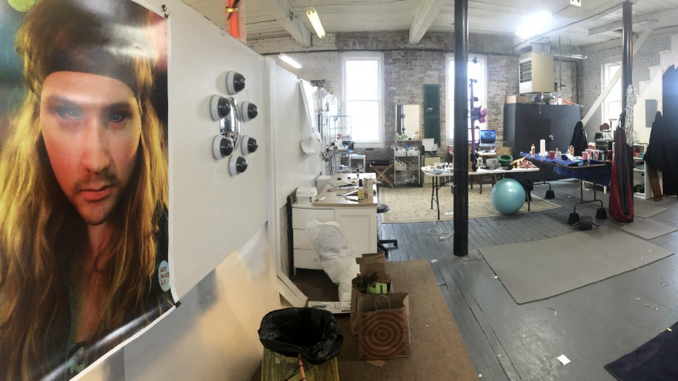 Studio loft with exposed brick walls and a portrait hanging on the wall