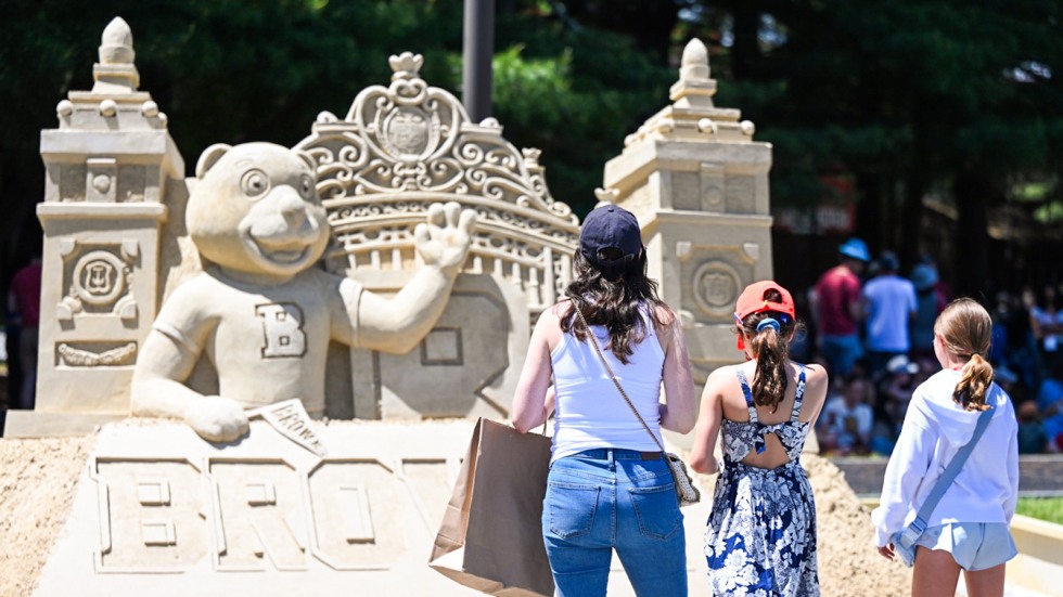 Family admiring sand sculpture at Block Party