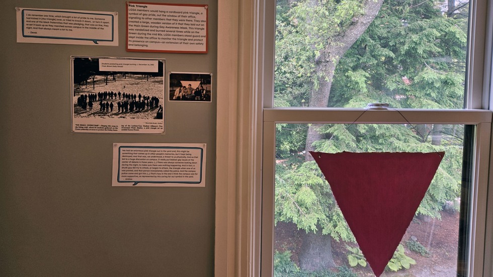 Pink cardboard triangle hangs in a window