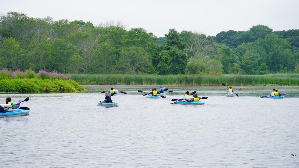 students explore river on kayaks 