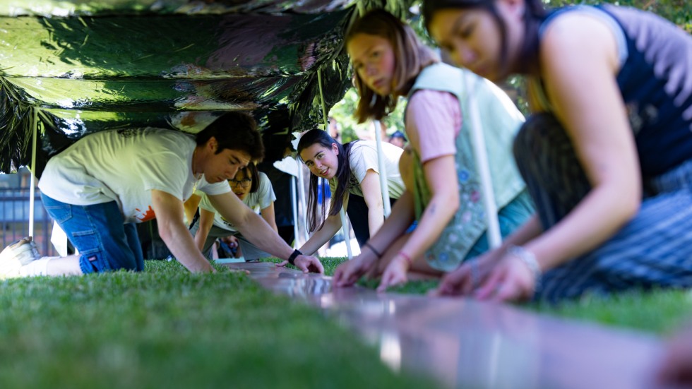 volunteers unroll film onto silk 