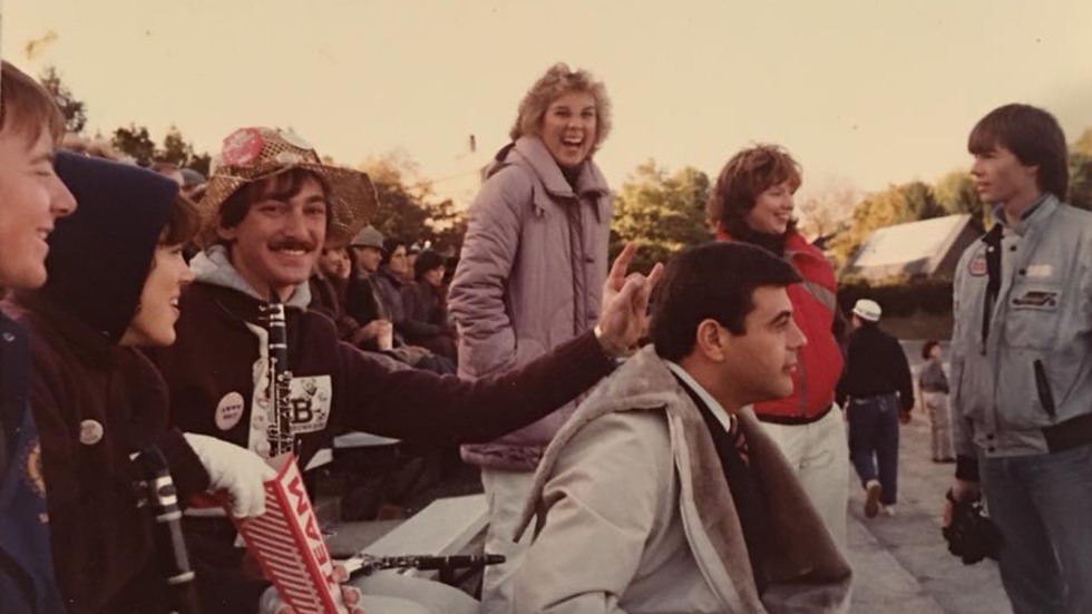 Archival image of band member giving Buddy Cianci bunny ears at Brown football game