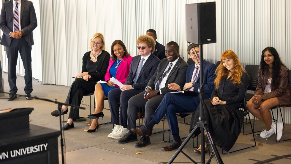 Students and elected officials sit together during remarks