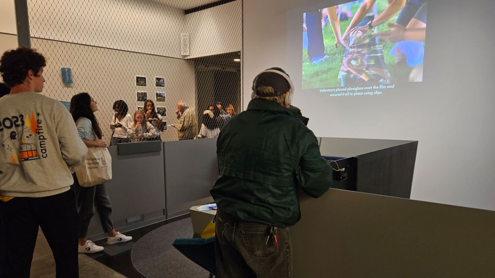 Attendees watch a film documenting the process