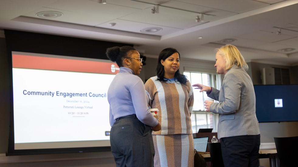 Wallace speaks with colleagues at a meeting