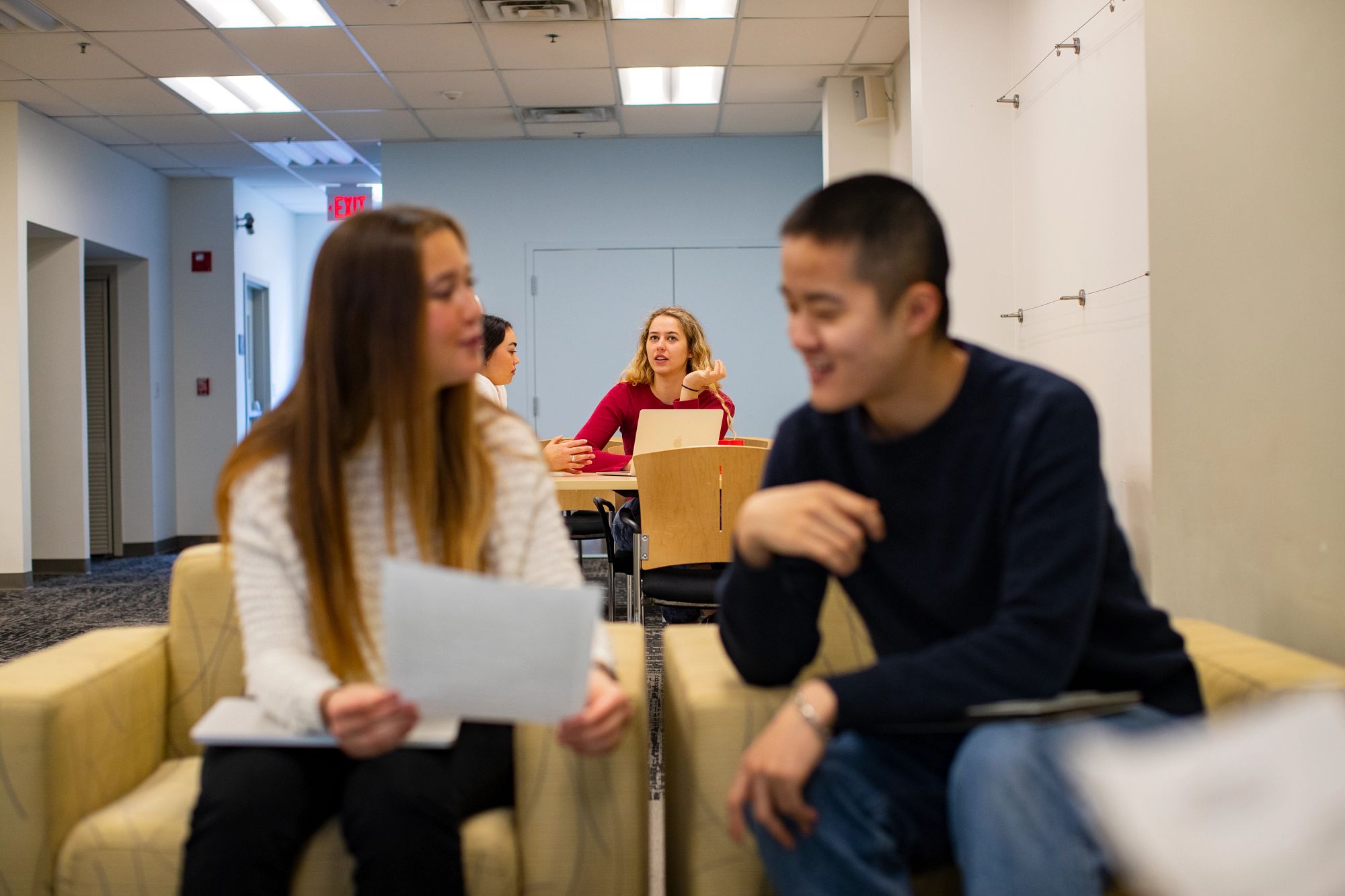 Two student seated, talking to each other